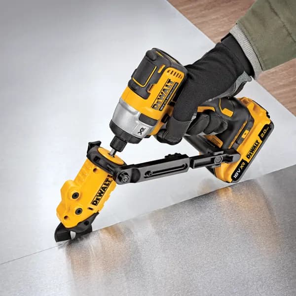 DEWALT power tool with attachment cutting sheet metal, operated by a gloved hand.